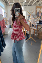 Load image into Gallery viewer, Person wearing a red and white checkered top and blue jeans taking a mirror selfie in a store.
