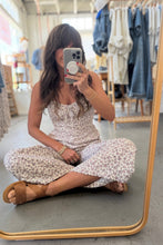 Load image into Gallery viewer, Woman taking a mirror selfie wearing a floral dress in a clothing store.
