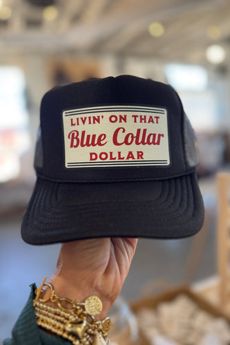 Black cap with 'Livin' on that Blue Collar Dollar' text held by a person.