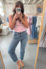 Load image into Gallery viewer, Person taking a mirror selfie wearing a pink top and blue jeans in a clothing store.