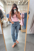Load image into Gallery viewer, Woman taking a mirror selfie wearing a pink tank top and blue jeans in a clothing store.