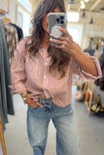 Load image into Gallery viewer, Person wearing a striped shirt and jeans in a clothing store.