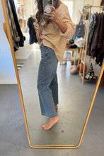 Load image into Gallery viewer, Person taking a mirror selfie wearing a striped shirt and jeans in a clothing store.