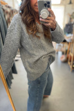 Load image into Gallery viewer, Person wearing a gray sweater and blue jeans taking a mirror selfie.