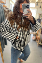 Load image into Gallery viewer, Person wearing a black and white checkered jacket in a clothing store.