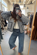 Load image into Gallery viewer, Person wearing a checkered jacket and jeans in a clothing store.