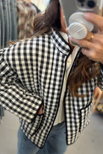 Load image into Gallery viewer, Person wearing a black and white checkered jacket taking a mirror selfie.