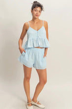 Load image into Gallery viewer, Woman wearing a light blue peplum top and shorts set on a plain background