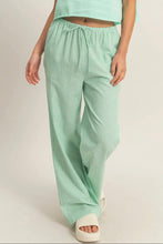 Load image into Gallery viewer, Person wearing light green striped pants and a matching top on a plain background