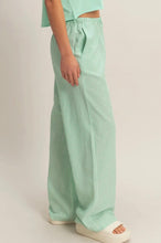 Load image into Gallery viewer, Person wearing light green striped pants on a plain background