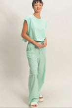Load image into Gallery viewer, Woman wearing a light green outfit on a plain background