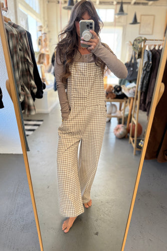 Person wearing a checkered outfit in a clothing store.