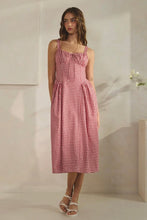 Load image into Gallery viewer, Woman wearing a red and white checkered dress in a minimalistic setting