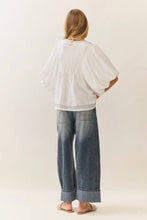 Load image into Gallery viewer, Person wearing a white oversized shirt and blue jeans on a plain background