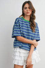 Load image into Gallery viewer, Woman wearing a blue and green striped shirt with a white ruffled skirt on a gray background