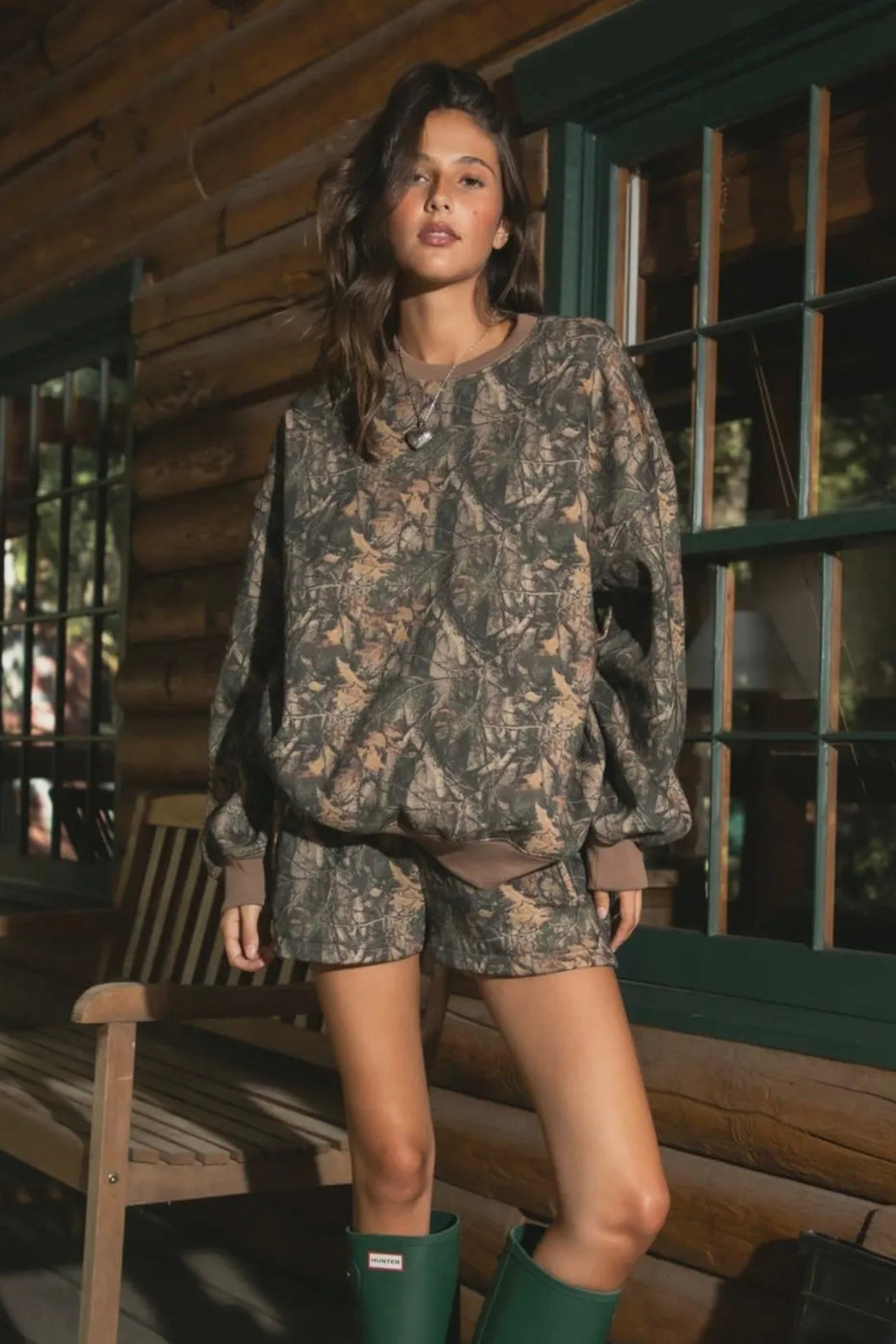 Woman in camouflage outfit standing on a wooden porch