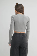 Load image into Gallery viewer, Person wearing a gray long-sleeve crop top and dark pants on a light gray background