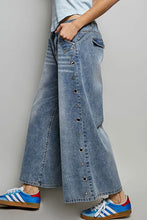 Load image into Gallery viewer, Person wearing wide-leg button-up jeans with a plain background