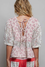 Load image into Gallery viewer, Woman wearing a floral blouse with a tie-back design on a plain background