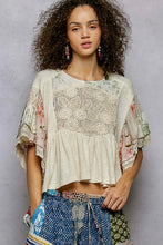 Load image into Gallery viewer, Woman wearing a floral top and patterned pants against a gray background