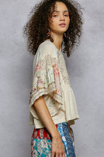 Load image into Gallery viewer, Woman wearing a floral kimono-style top against a gray background