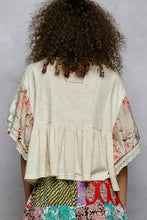 Load image into Gallery viewer, Person wearing a floral kimono-style top with a plain background
