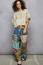Load image into Gallery viewer, Woman wearing a patterned outfit with a plain background