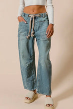 Load image into Gallery viewer, Person wearing light blue denim jeans with a beige background