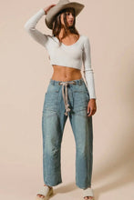 Load image into Gallery viewer, Woman wearing a white long-sleeve crop top and blue jeans with a beige hat on a beige background
