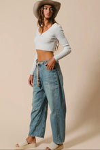 Load image into Gallery viewer, Woman wearing a white crop top and blue jeans with a beige hat on a beige background