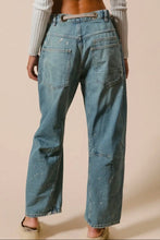 Load image into Gallery viewer, Person wearing blue jeans on a beige background