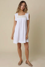 Load image into Gallery viewer, Woman wearing a white dress with lace details on a beige background