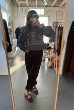 Load image into Gallery viewer, Person taking a mirror selfie wearing a textured sweater and brown pants in a store.