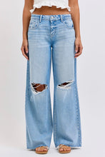 Load image into Gallery viewer, Person wearing light blue jeans with distressing details on a white background