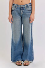 Load image into Gallery viewer, Person wearing blue flared jeans on a white background