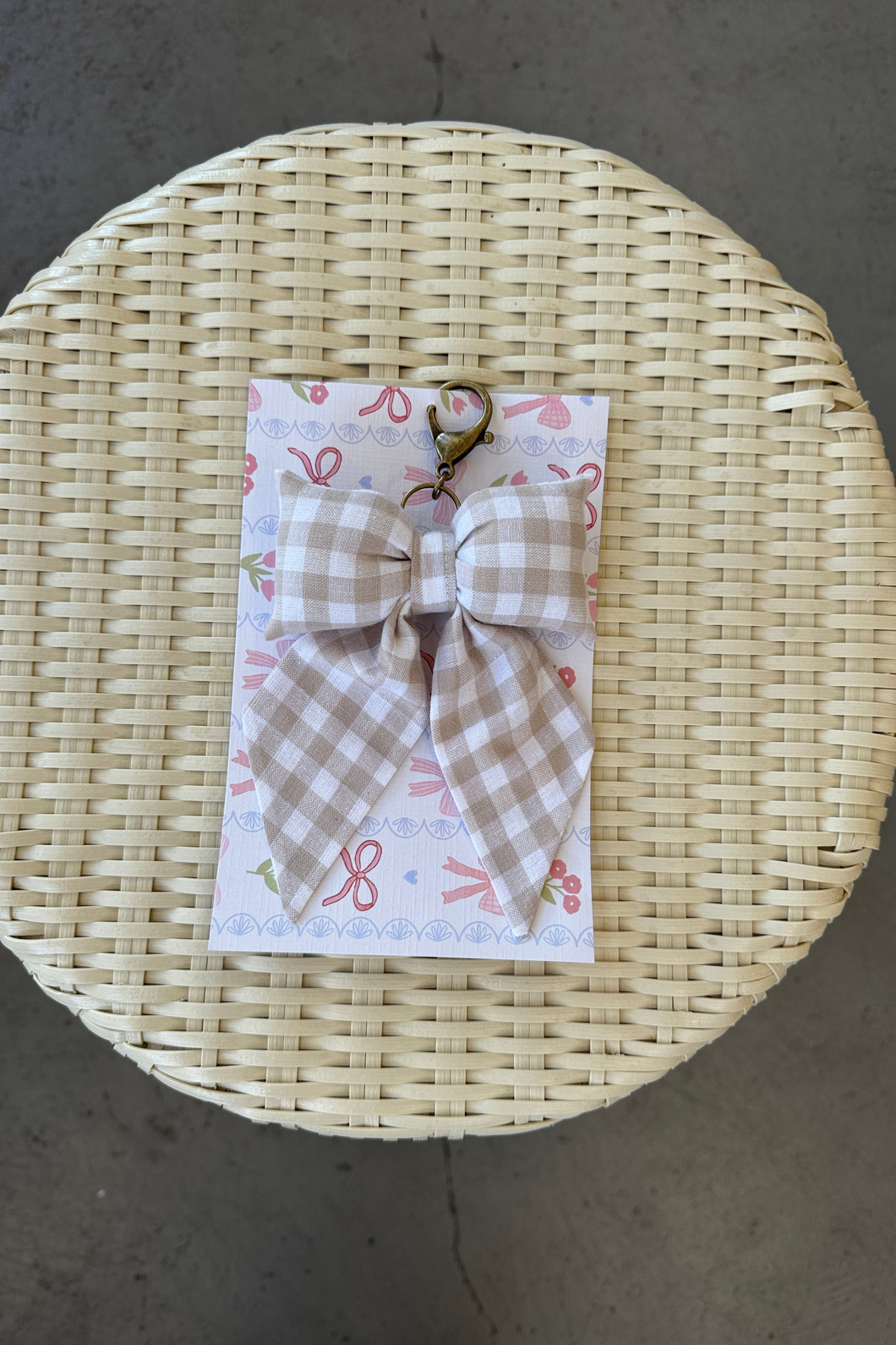 Woven basket with a checkered bow and decorative paper on a concrete surface