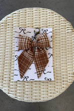 Load image into Gallery viewer, Woven basket with a card featuring a brown plaid bow on a gray surface