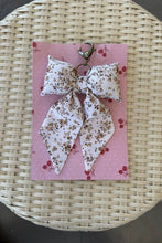 Load image into Gallery viewer, Floral-patterned hair bow on a pink card with red berries, placed on a woven surface.