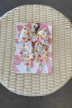 Load image into Gallery viewer, Floral bow hair clip packaging on a woven surface