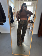 Load image into Gallery viewer, Person taking a mirror selfie wearing a brown top and camouflage pants in a room with a large mirror.