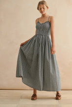 Load image into Gallery viewer, Woman wearing a black and white checkered dress against a beige background
