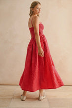 Load image into Gallery viewer, Woman wearing a red checkered dress against a beige background