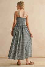 Load image into Gallery viewer, Woman wearing a black and white checkered dress against a beige background