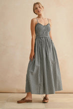 Load image into Gallery viewer, Woman wearing a black and white checkered dress against a beige background