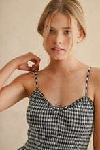 Load image into Gallery viewer, Woman wearing a black and white checkered dress against a beige background