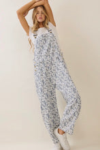 Load image into Gallery viewer, Woman wearing a floral jumpsuit on a plain background