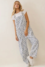 Load image into Gallery viewer, Woman wearing a floral overalls and white t-shirt on a plain background