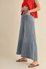 Load image into Gallery viewer, Person wearing a red top and blue denim wide-leg pants on a beige background
