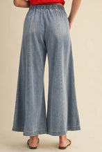 Load image into Gallery viewer, Light blue denim wide-leg pants worn by a person on a beige background
