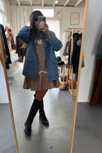 Load image into Gallery viewer, Person taking a mirror selfie wearing a blue denim jacket, striped dress, and black knee-high boots in a clothing store.